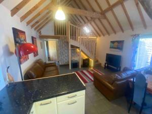 a living room with a couch and a table at Seafret Barn sleeps two, North Norfolk in Roughton