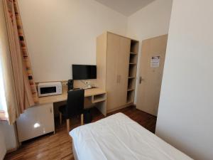 a room with a desk with a computer and a bed at Apart1hotel in Luxembourg