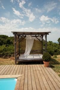 un letto su una terrazza in legno accanto alla piscina di VILLA BARQUEIRO a Coti-Chiavari
