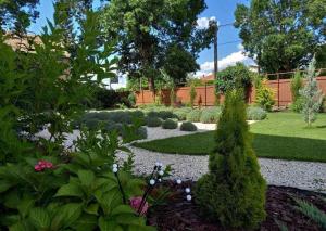 einen Garten mit Büschen und Blumen im Hof in der Unterkunft Bokor Vendégház in Szentes