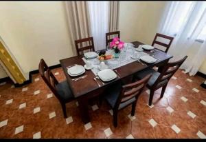 - une table à manger avec des chaises, des assiettes et des fleurs dans l'établissement Mtwapa Villa, à Mombasa