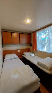 two beds in a small room with a window at Camping Bella Vista in Ceriale