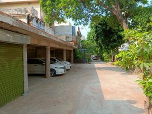 une rue avec deux voitures garées à côté d'un bâtiment dans l'établissement Samrat Hotel, à Ludhiana