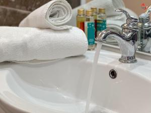 a bathroom sink with a white towel and a faucet at Chez Zèlou in Sainte-Anne