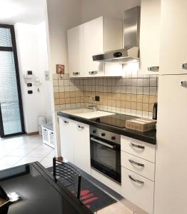 ボローニャにあるMaison Paradiso - Santa Viola Apartmentのキッチン(白いキャビネット、シンク、コンロ付)