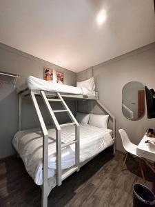 a bedroom with two bunk beds and a desk at Lugano Arte Homestay in Jakarta
