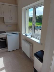 a kitchen with a window and a white refrigerator at Harmony Haven Cottage in Foxford