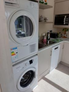 uma cozinha com uma máquina de lavar roupa e uma máquina de lavar roupa em Harmony Haven Cottage em Foxford