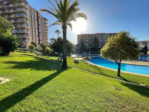 a park with a swimming pool and palm trees at EXKLUSIVA LÄGENHET I BENALMADENA in Benalmádena