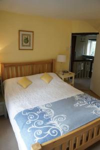 - une chambre dotée d'un lit avec une couverture bleue et blanche dans l'établissement IVY COTTAGE, à Pulborough