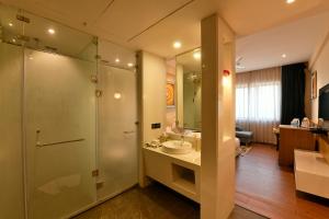 un bagno con doccia, lavandino e specchio di Pal Heights Mantra a Bhubaneshwar