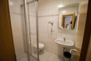 a bathroom with a shower and a toilet and a sink at Gasthof zur Länd in Moosburg