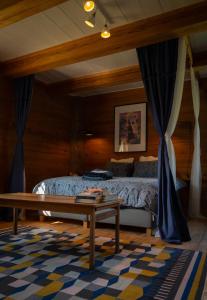 Schlafzimmer mit einem Bett und einem Couchtisch in der Unterkunft La Maison Rouge de Slätten Bed and Breakfast in Vilshult