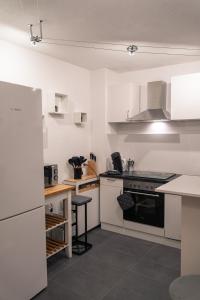 a kitchen with white cabinets and a stove top oven at Ferienwohnung Naturini in Freiburg im Breisgau