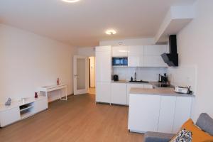 cocina abierta y sala de estar con armarios blancos en Holešovice Delight: Modern Comfort with a Twist in Prague 7, en Praga