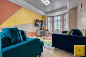 a living room with two blue chairs and a tv at 4 Bedroom, 6 Beds, 3 Bathrooms, Near NEC & Birmingham Airport, Business, Contractor and Family Friendly, Free Wi-Fi, Free Parking in Coventry