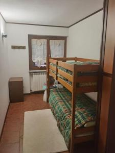 a bedroom with two bunk beds and a window at Il giardino sulle Piste in Prato Nevoso