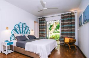 ein Schlafzimmer mit einem großen Bett und einem Fenster in der Unterkunft Tree Lodge Mauritius Villa in Argy