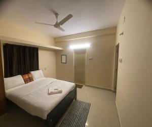 1 dormitorio con 1 cama y ventilador de techo en The waves en Chennai