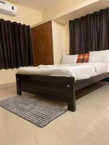 a bed sitting in a room with a window at The waves in Chennai