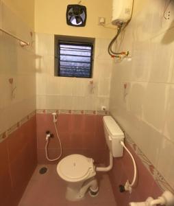 a small bathroom with a toilet and a window at The waves in Chennai