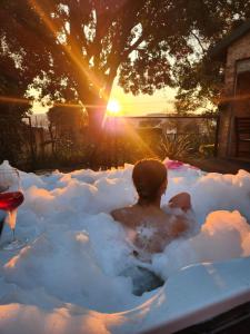 a man sitting in a bath tub in the snow at Sanctuary on Lois - under 1km from hospital - load shedding free in Pretoria