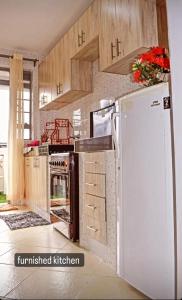 una cucina con piano cottura e frigorifero di Lighthomes31 a Thika
