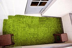 a green wall in a room with two benches at Lighthomes31 in Thika