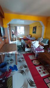 Habitación con 2 camas y sala de estar. en Rambler's Nesting Homestay, en Darjeeling