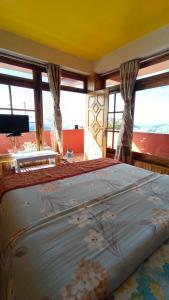 ein großes Bett in einem Zimmer mit Fenstern in der Unterkunft Rambler's Nesting Homestay in Darjeeling