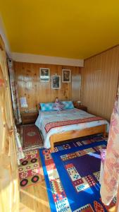 a bedroom with a bed in a room with wooden walls at Rambler's Nesting Homestay in Darjeeling