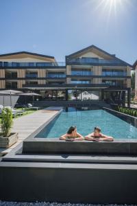 two people in a swimming pool in a building at Montanaris Alpine - Active - Relax in Villabassa
