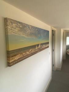 a painting of the ocean on a wall at Oyster Barn sleeps six, North Norfolk in Roughton