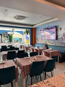 un restaurante con mesas y sillas y una gran ventana en Kiwi Boutique Hotel, en Patong Beach