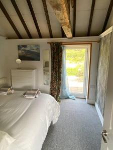 a bedroom with a bed and a large window at Oyster Barn sleeps six, North Norfolk in Roughton