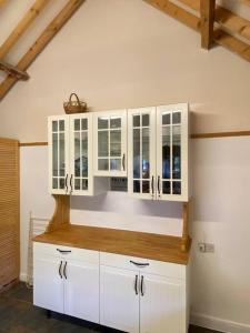 a kitchen with white cabinets and a counter top at Oyster Barn sleeps six, North Norfolk in Roughton