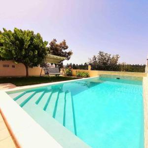 a large blue swimming pool in front of a house at Paradise House Ground floor apartment in Villa with private pool and private garden in Abrantes