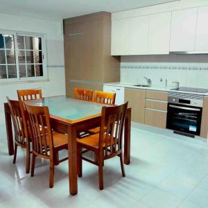 a kitchen with a wooden table and chairs in it at Paradise House Ground floor apartment in Villa with private pool and private garden in Abrantes