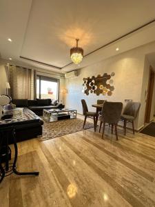 een grote woonkamer met een tafel en stoelen bij CHIC & COZY appartement très calme in Casablanca