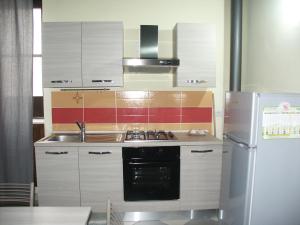 a kitchen with a sink and a refrigerator at Il soppalco in Avola