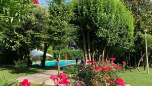 um jardim com piscina, árvores e flores em Villa Valmarana De Toni em Creazzo