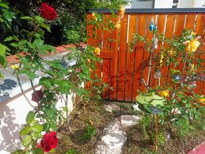 un jardin avec des roses et une clôture en bois dans l'établissement Un moment de douceur, à Nancy
