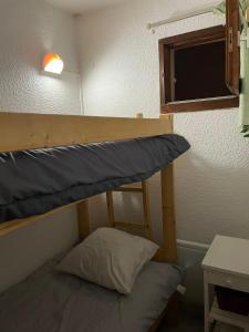 a bunk bed in a room with a pillow at Appartement pour 6 personnes au pied des pistes au calme aux Menuires les Asters in Les Menuires