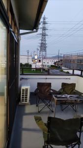 Duas cadeiras e uma mesa numa varanda com vista em 古民家貸し切り0818変則あり最大10人まで em Gifu