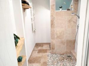 a bathroom with a shower with a tiled floor at Appartement au rez-de-chaussée in Souillac
