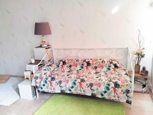 a bed with a floral comforter in a bedroom at Appartement au rez-de-chaussée in Souillac