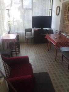sala de estar con TV, mesa y sillas en VILA MILA SOKOBANJA en Soko Banja