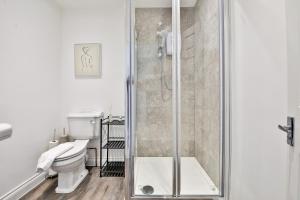 a bathroom with a toilet and a glass shower at StayRight Spacious Apartments with Private Parking- 15-Minute Stroll to Town Centre in Cardiff