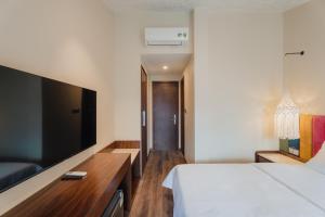 a bedroom with a bed and a flat screen tv at May Casa in Sapa