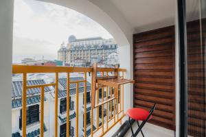 a balcony with a red chair and a view of the city at May Casa in Sa Pa